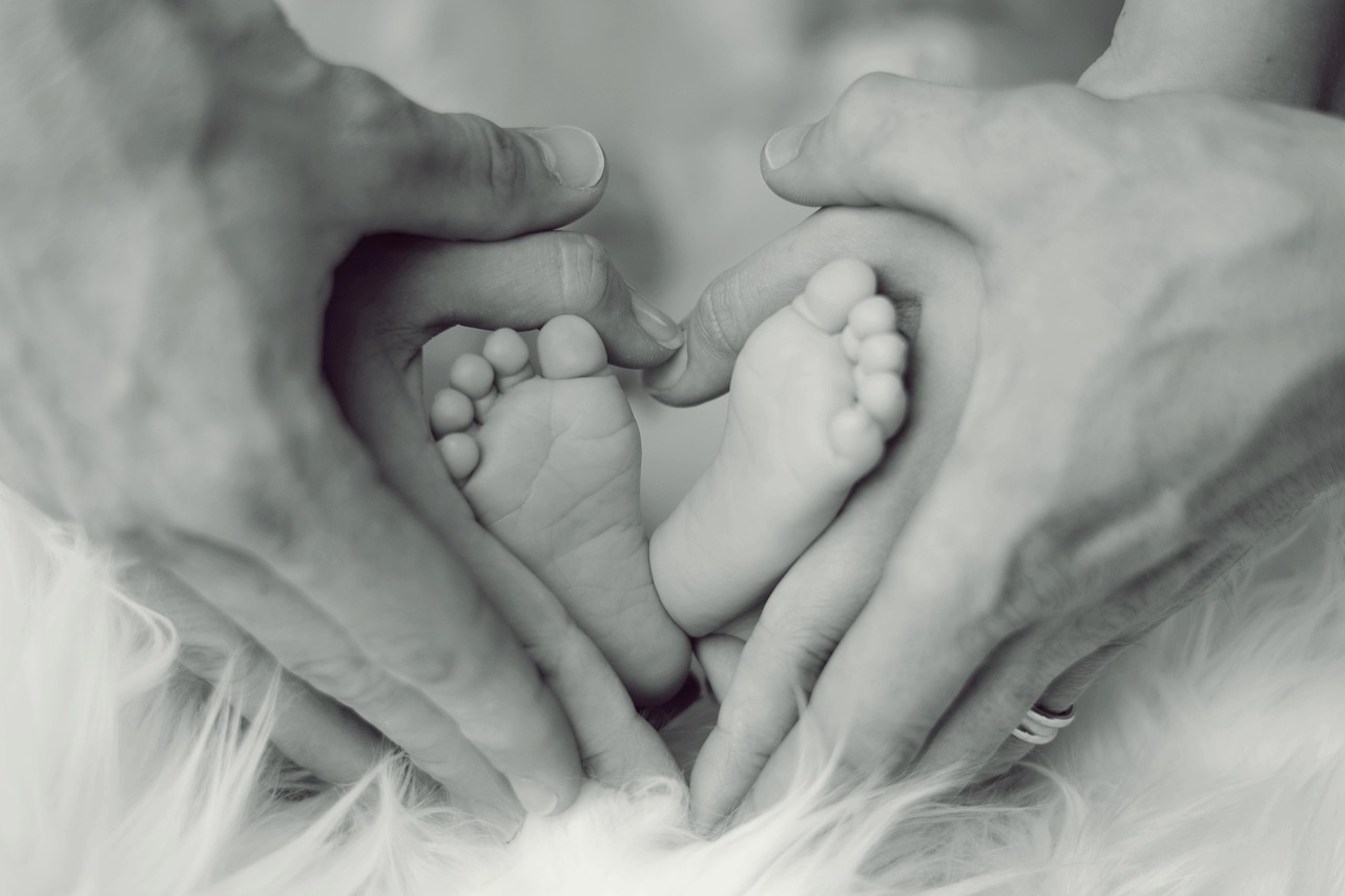 Un parent tient les pieds de son nouveau-né