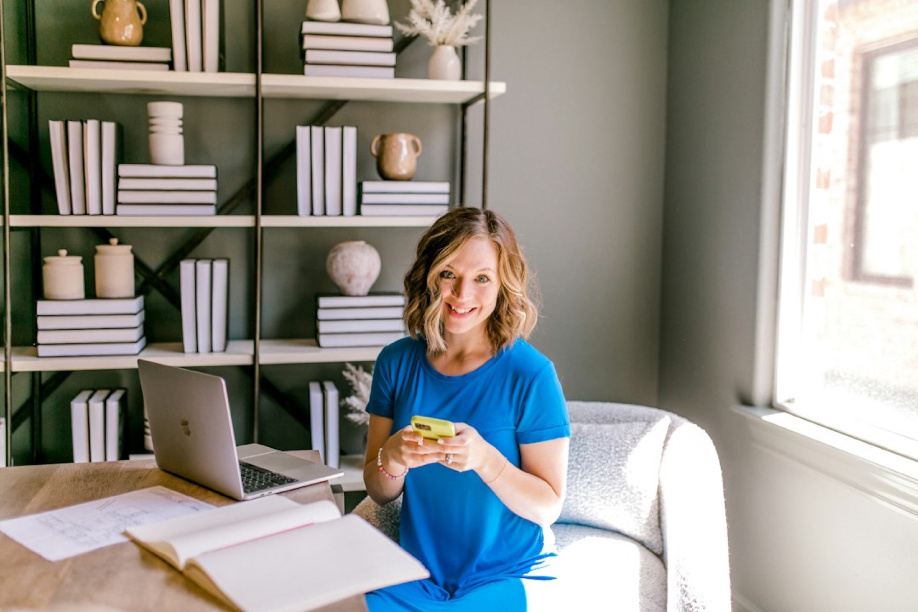 femme installée à un bureau avec un ordinateur portable et des documents, en train de comparer des offres
