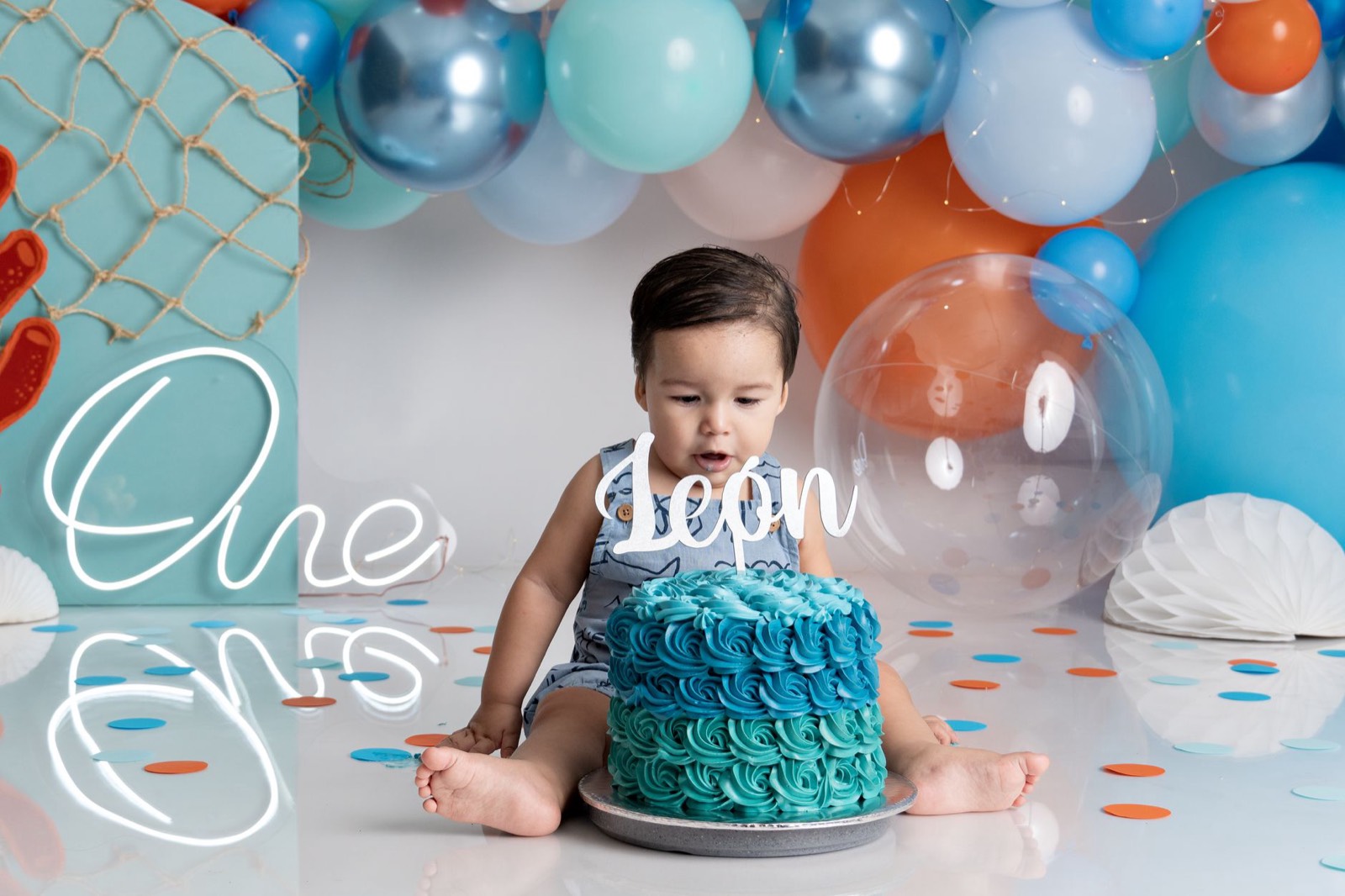 Gâteau d'anniversaire d'un tout-petit entouré de ballons pour ses 1 an