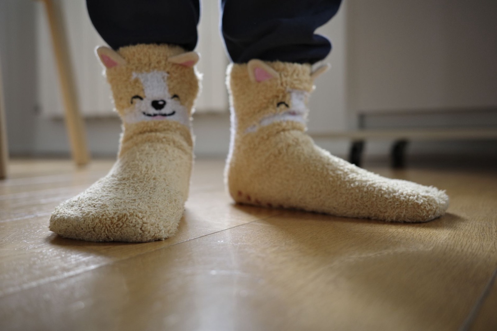 Pieds d'un tout-petit en chaussettes sur un parquet en bois