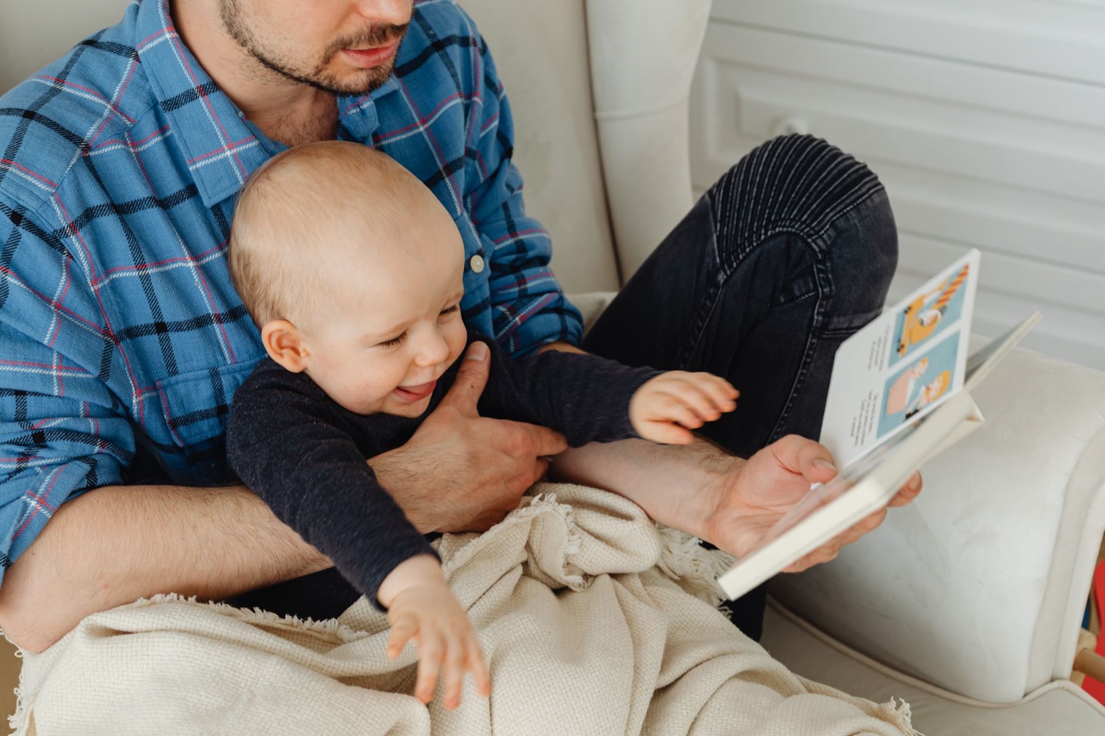 Un parent lit un livre à son bébé installé sur ses genoux