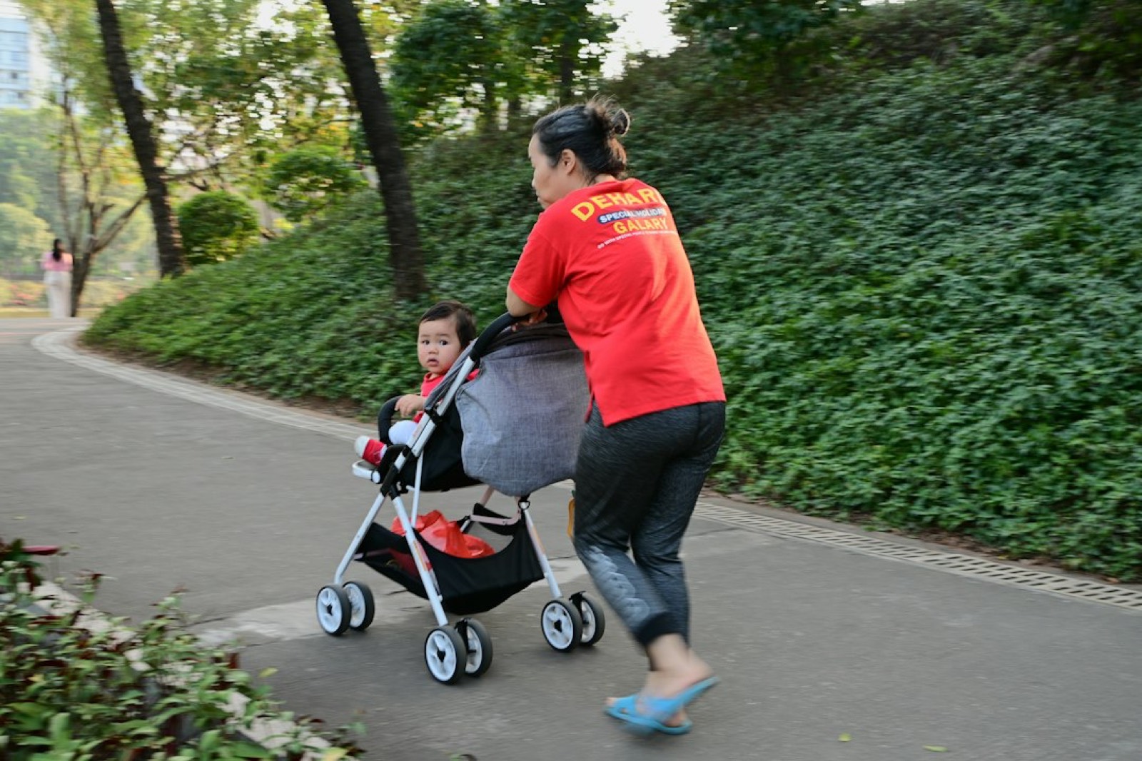 Jeune mère marchant avec une poussette dans un parc pendant sa rééducation post-partum